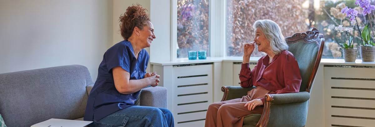 Zorgprofessional in gesprek met oudere dame