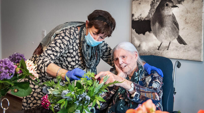 KIK-V Zorgmedewerkster in verpleeghuis helpt met bloemen
